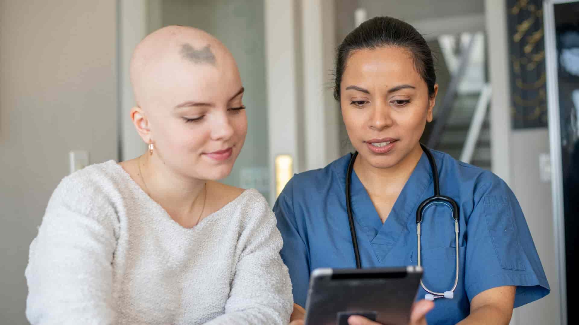 Fachkrankenpflegerin Onkologie spricht mit Patientin.
